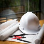 construction-concept-image-helmet-rolled-blueprints-wooden-boards-retro-style_1423-263